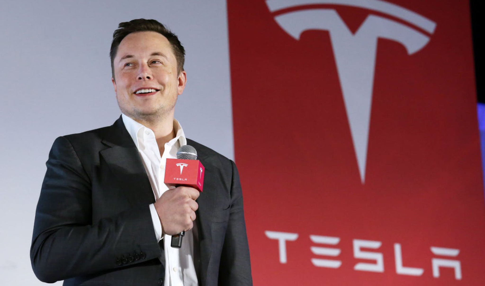 Elon Musk con logo Tesla